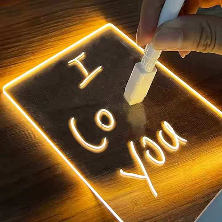 Mano borrando mensaje “I love you” en la pizarra luminosa LUMINA con rotulador borrable
